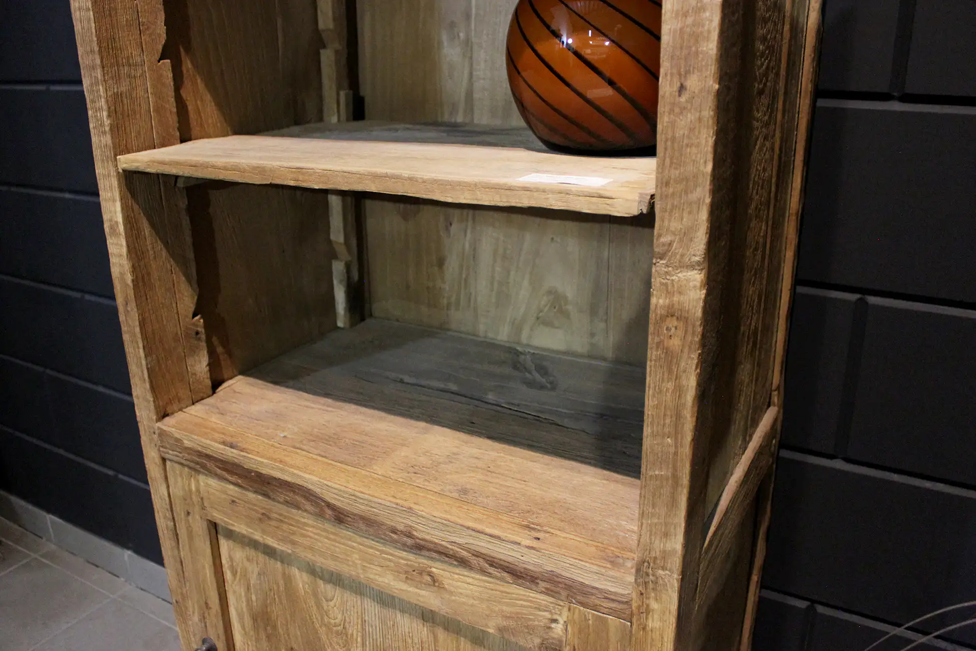 Cuci Bebas 70DE Old | schmales Bücherregal aus Teakholz Erosion Teakholz Schmaler Bücherschrank aus Teakholz in antikem Erosions-Teak. Dieser schmale Teakschrank hat offene Fächer und eine Drehtür.